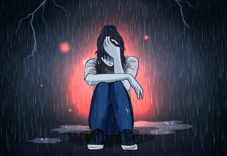 Depressed teenage girl sitting alone in the rain.