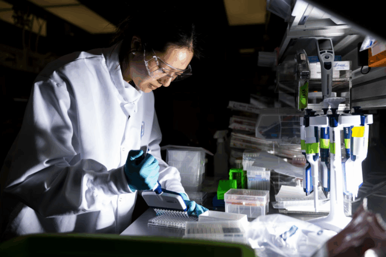 A researcher works in the lab at the Moderna Inc. headquarters in Cambridge, Mass. Moderna has been working to develop vaccines using the mRNA technology. Earlier this year the Trump administration pulled hundreds of millions of dollars committed to the support the drugmaker's research into flu vaccines and this week it cancelled another $500 million in grants to various institutions researching mRNA vaccines.