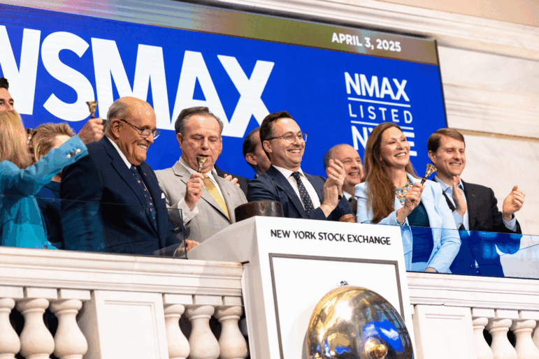 Newsmax will pay $67 million to Dominion Voting Systems to settle a lawsuit over the network's coverage of the 2020 presidential election. In this photo from April 3, 2025, Newsmax CEO Chris Ruddy and former New York City Mayor Rudy Giuliani join others at the opening of trading at the New York Stock Exchange.