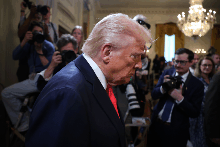 President Trump arrives for a presentation ceremony for the Commander-in-Chief Trophy to the U.S. Naval Academy Midshipmen at the White House on April 15 as photographers and reporters stand behind him.