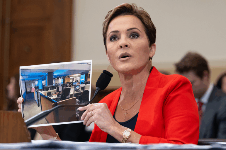 Kari Lake, who is overseeing the U.S. Agency for Global Media, holds up a photo of the Voice of America newsroom as she testifies during a House Foreign Affairs Committee hearing on the future of the agency on June 25, 2025. (Photo by SAUL LOEB / AFP) (Photo by SAUL LOEB/AFP via Getty Images)