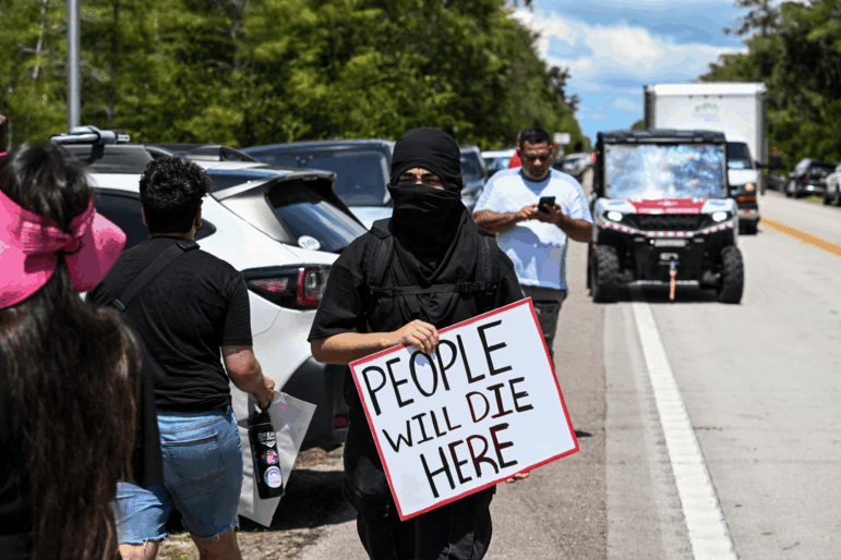 Protesters gather to demand the closure of the immigrant detention center known as "Alligator Alcatraz" at the Dade-Collier Training and Transition Airport in Ochopee, Fla., on July 22. Immigrants held at U.S. detention centers have experienced abusive and degrading treatment, a Human Rights Watch report said on July 21.