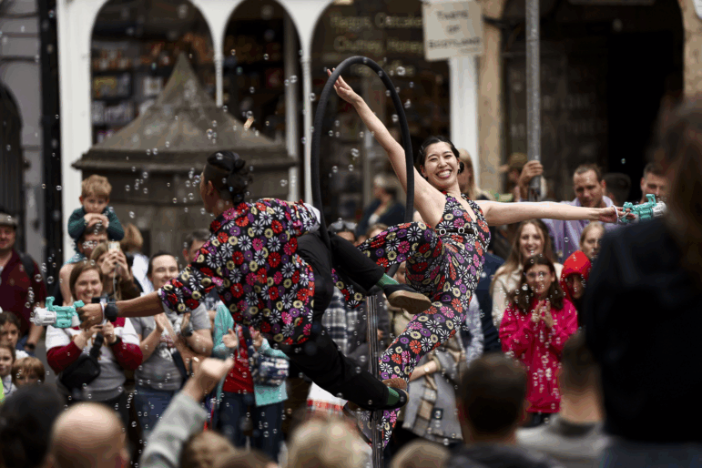 Street performers entertain passersby on the Royal Mile as crowds of entertainers and festival-goers gather for the Edinburgh Festival Fringe and Edinburgh International Festival in Edinburgh, Scotland, on Aug. 1, 2025. The Fringe, one of the world's largest performing arts festivals, features over 3,800 shows across 265 venues and draws an audience of roughly 3 million visitors.