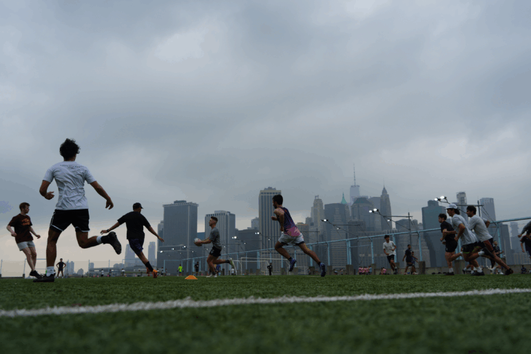 People play rugby in the hazy weather at Brooklyn Bridge Park on July 27, 2025 in New York City. Hazy conditions and a smoke advisory have been caused by smoke as a result of wildfire in Canada.
