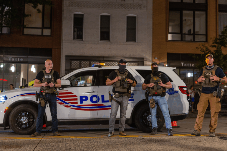 Police officers set up a roadside checkpoint on 14th Street Northwest on Wednesday in Washington, D.C. President Trump deployed federal officers and the National Guard in order to place the D.C. Metropolitan Police Department under federal control and assist in crime prevention in the nation's capital.