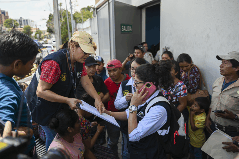 Staffers of the Attorney General's Office take the data of relatives outside of the Returnee Reception Center while waiting for the arrival of minors deported from the United States, at the Guatemalan Air Force Base in Guatemala City on August 31, 2025. (Photo by Johan ORDONEZ / AFP) (Photo by JOHAN ORDONEZ/AFP via Getty Images)