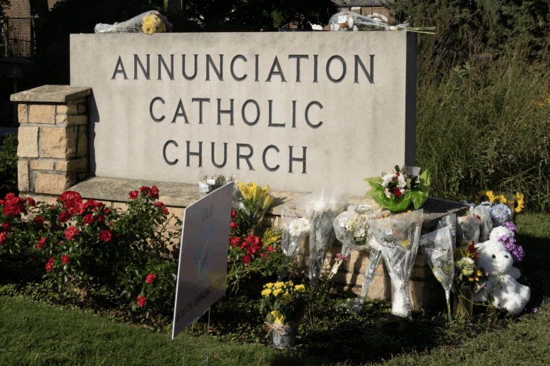A memorial to shooting victims, consisting of flower bouquets, sits at the front sign of Annunciation Catholic Church in Minneapolis on August 28, 2025.