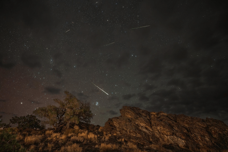 Meteors from the Perseids Meteor Shower streak across a partly cloudy sky above Inyo National Forest in Bishop, California, in 2024.
