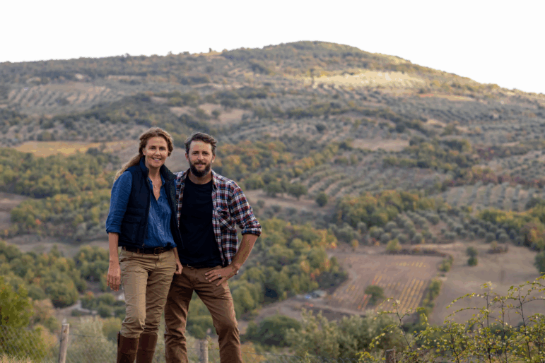 Siblings Marie-Charlotte Piro and Romain Piro stand among some of the olive trees they harvest in Tuscany, Italy, to create their olive oil.