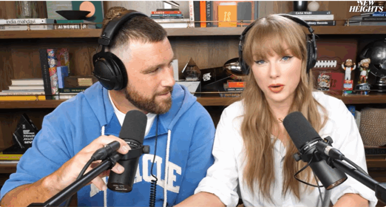 Travis Kelce looks at Taylor Swift during Wednesday's episode of New Heights.