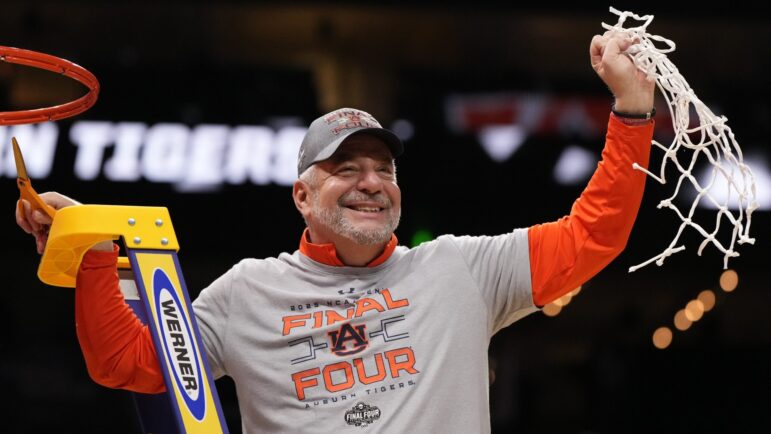 Auburn head coach Bruce Pearl celebrates with a net after the Elite Eight of the NCAA college basketball tournament against Michigan State in Atlanta.
