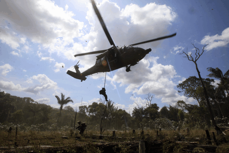 Police rappel from a helicopter to destroy a cocaine processing lab in Puerto Concordia in Colombia's southern Meta state.