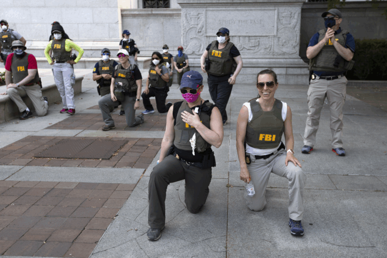 FBI personnel take a knee with demonstrators that were marching on Pennsylvania Avenue in Washington, D.C., on June 4, 2020, during a protest over the death of George Floyd.