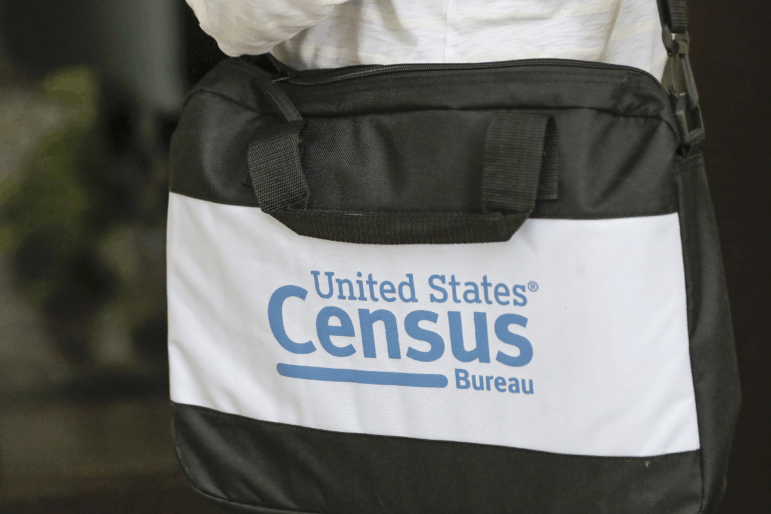 A door knocker carries a U.S. Census Bureau messenger bag outside a home in Winter Park, Fla., in 2020.