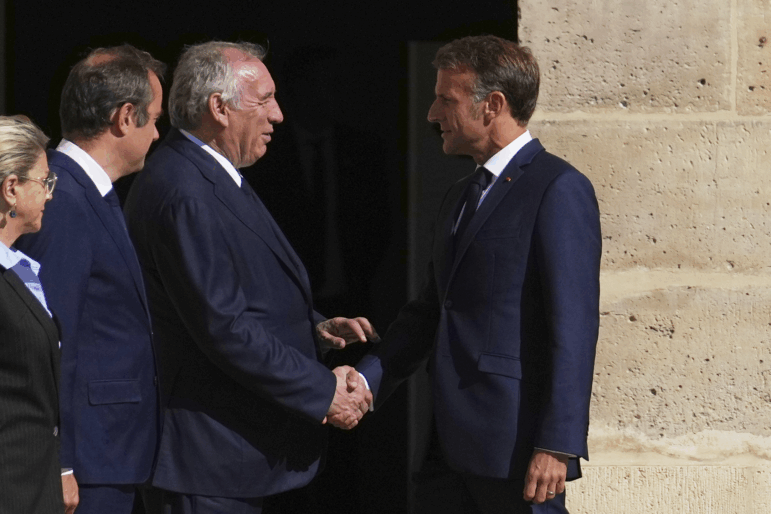 France's President Emmanuel Macron, right, shakes hands with France's Prime Minister Francois Bayrou during the farewell ceremony of Chief of Staff of the French Armed Forces Thierry Burkhard, in the courtyard of the Invalides, in Paris, France, last Friday, Sept. 5, 2025. (AP Photo/Christophe Ena, Pool)