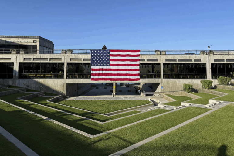 A national flag hangs over the site where conservative activist Charlie Kirk was shot and killed at Utah Valley University last week. Experts say foreign governments have been doing their best to spin events to fit their narratives.