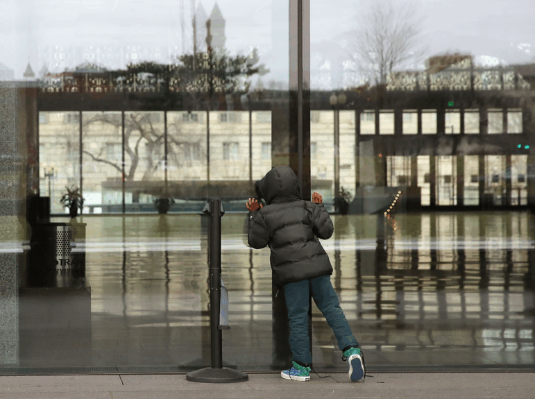 A young visitor peers inside the National Museum of African American History that closed due to the partial shutdown of the U.S. government in January 2019 in Washington, D.C.