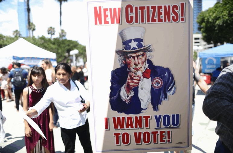 A sign is posted at a voter registration booth outside a naturalization ceremony at the Los Angeles Convention Center on July 23, 2019.