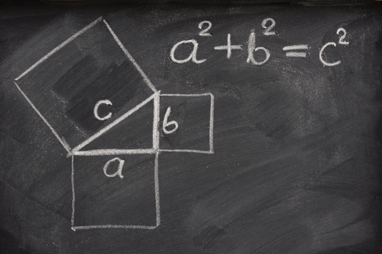 This photo shows a blackboard on which is written in white chalk: a^2 + b^2 = c^2. Also drawn on the chalkboard is a right triangle with its sides labeled a, b and c and with each side forming one side of a square that extends out from that side of the triangle.