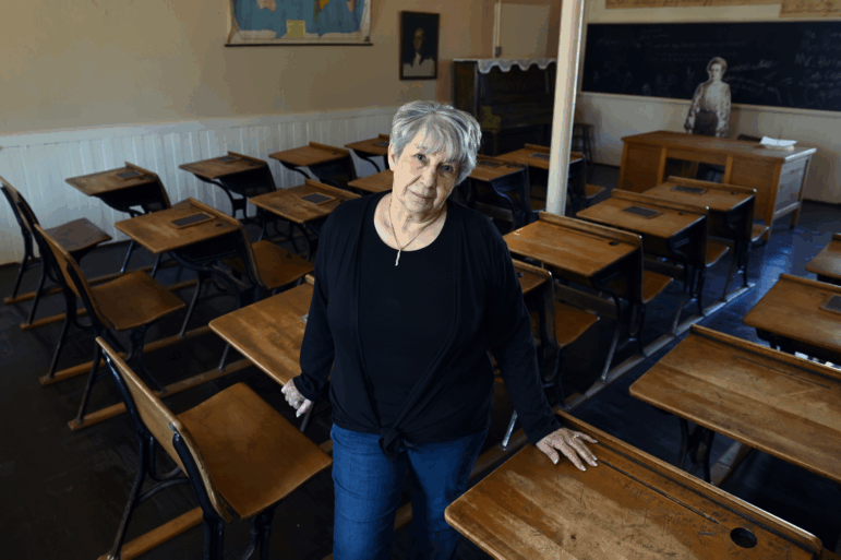 Ramona Klein poses for a photo in a classroom at the former Fort Totten Indian Industrial School in North Dakota. Klein attended the boarding school from 1954 to 1958.