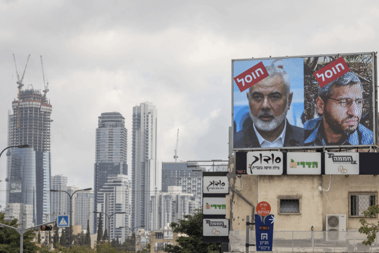 A billboard displays portraits of Hamas leaders Mohammed Deif and Ismail Haniyeh with the word "assassinated" in Hebrew, in Tel Aviv, Aug. 2, 2024.