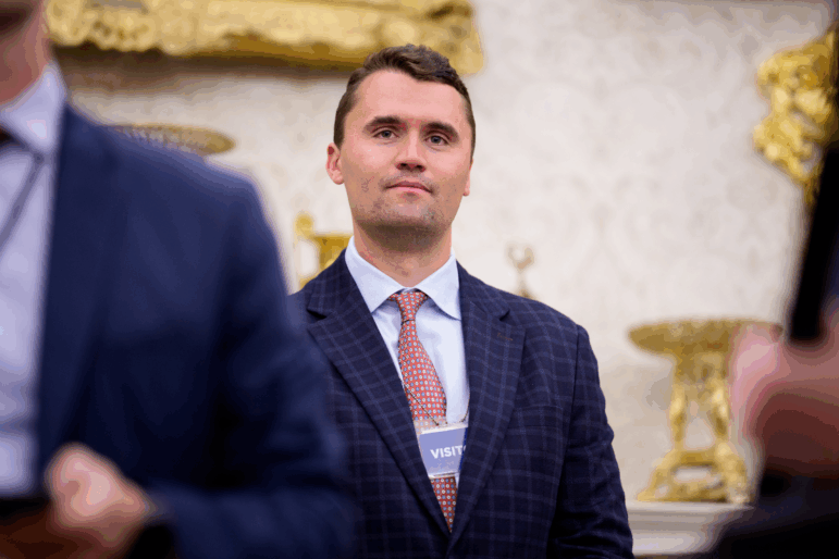 Turning Point USA co-founder Charlie Kirk stands in the back of the room as President Trump speaks during a swearing in ceremony for interim U.S. Attorney for Washington, D.C. Jeanine Pirro in the Oval Office of the White House on May 28.