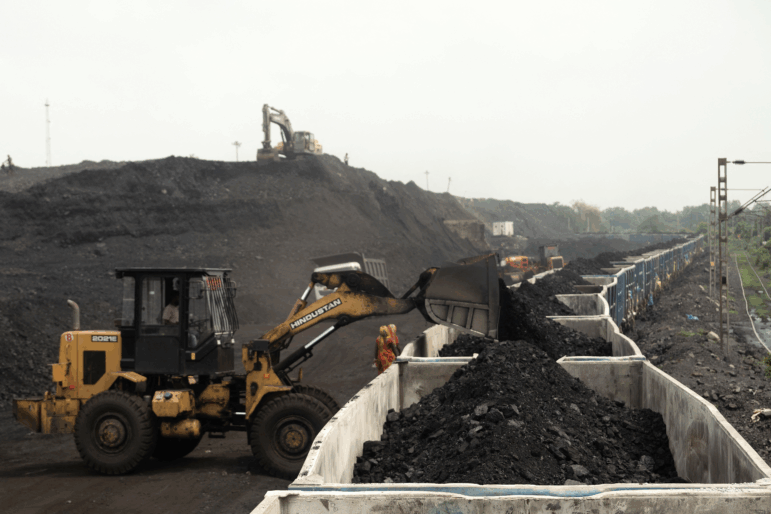 On the outskirts of Dhanbad, in India's Jharkhand state, heaps of coal are loaded onto a train car in August. India is world's third-largest greenhouse gas polluter and relies heavily on coal for electricity generation.