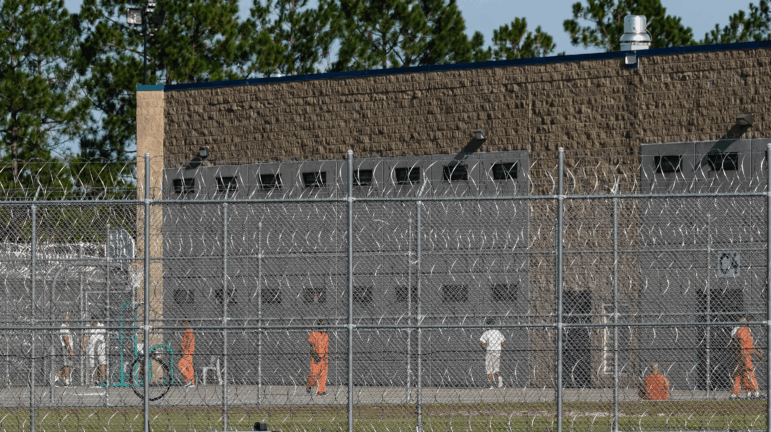 Detainees are seen in a yard at the Folkston ICE Processing Center on Sept. 9, 2025, in Folkston, Georgia. The state's two Democratic senators are demanding answers from the Department of Homeland Security after more than a dozen people have died in immigration detention facilities.