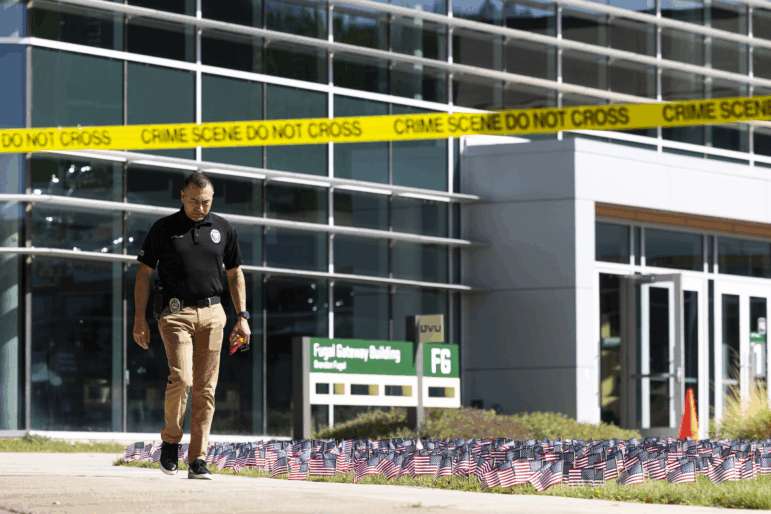 A police officer walks out of a building at Utah Valley University as authorities investigate the fatal shooting of political activist Charlie Kirk. Conservative influencers have reacted with grief and anger to Kirk's killing.
