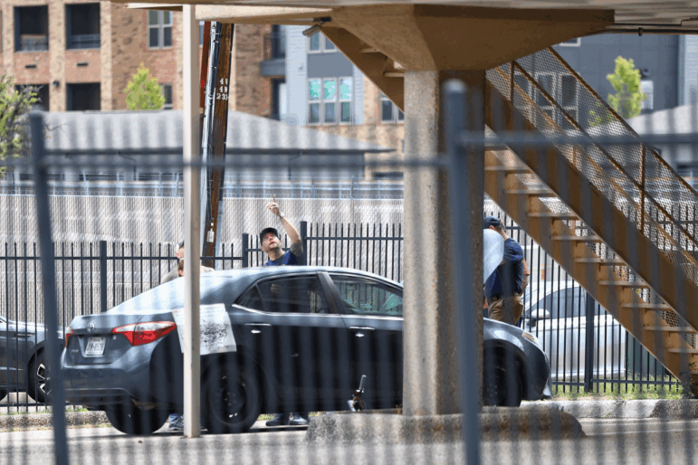 FBI and other law enforcement officials investigate a vehicle parked near the building allegedly used by the gunman, following a shooting near an Immigration and Customs Enforcement detention facility in Dallas on Wednesday.