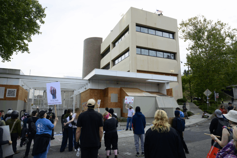 Federal agents observe the crowd of protesters outside of the ICEt building on Sept. 28 in Portland, Oregon.