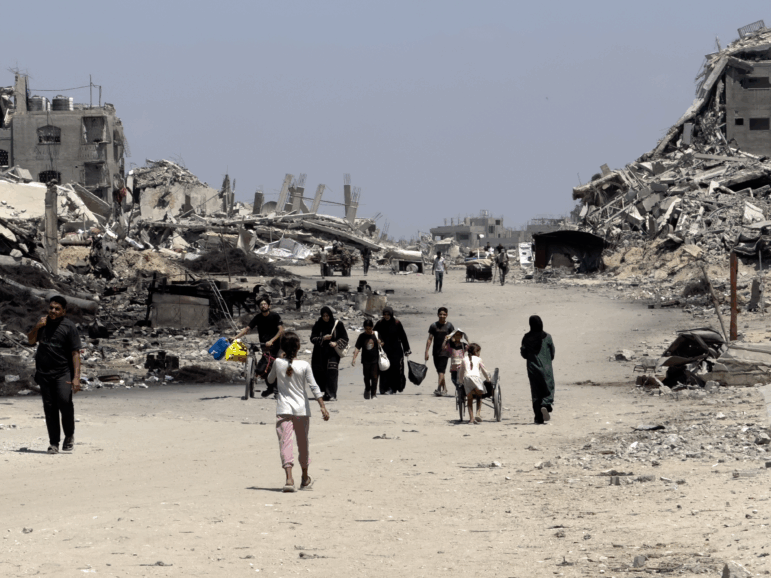 Families leave northern neighborhoods of Gaza City with the few items they can carry on Aug. 26, after Israeli tanks and airstrikes force them out.