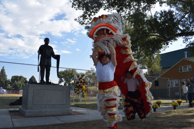 Lion Dancers perform in front of a new statue of a Chinese coal miner in Rock Springs, Wyoming called "Requiem"