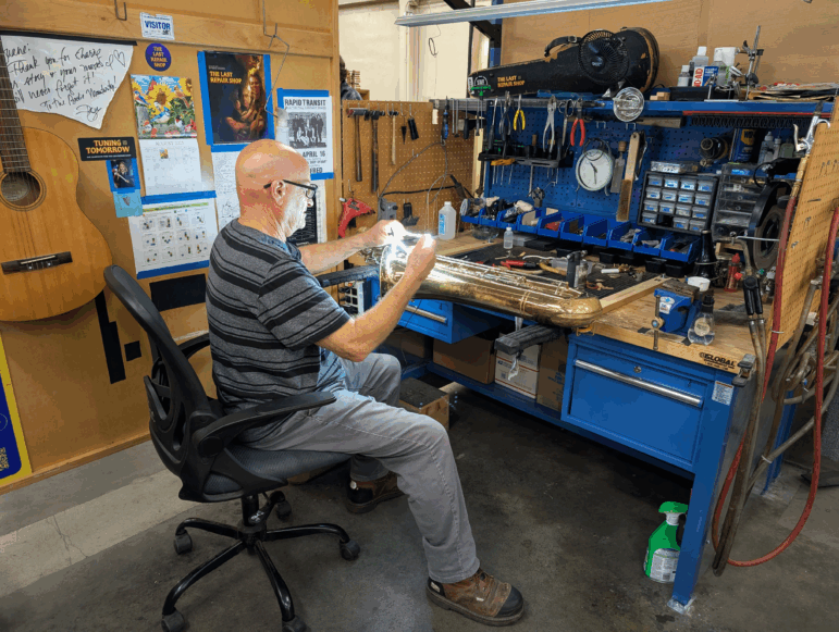 Repair technician Duane Michaels solders a dented saxophone for an LAUSD student. He specializes in woodwind instruments.