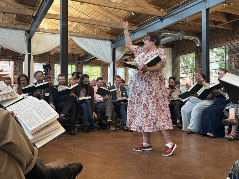 Musicologist Angharad Davis of Australia leads the song she composed for the new edition of The Sacred Harp, "Radiance," in the center of the hollow square.