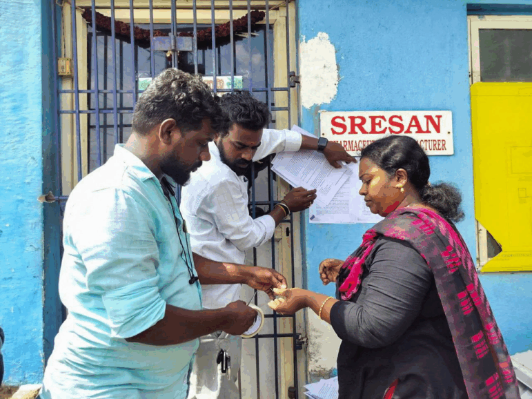 A state health official sticks a notice outside the Sresan Pharmaceutical factory whose Coldrif cough syrup has been linked to the deaths of more than 20 children in India, October 7, 2025.