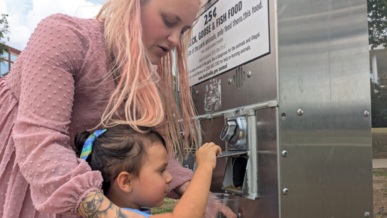 Rachel Ramos and her daughter, Raina, feed ducks at a Huntsville, Alabama, park on September 22, 2025.