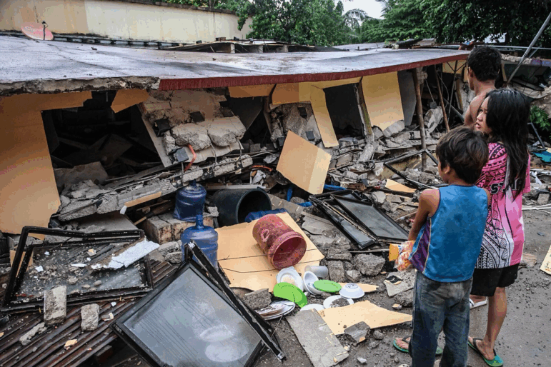 People look at a collapsed building in Bogo City, Cebu province, Philippines Wednesday, Oct. 1, 2025 after an offshore earthquake on late Tuesday.
