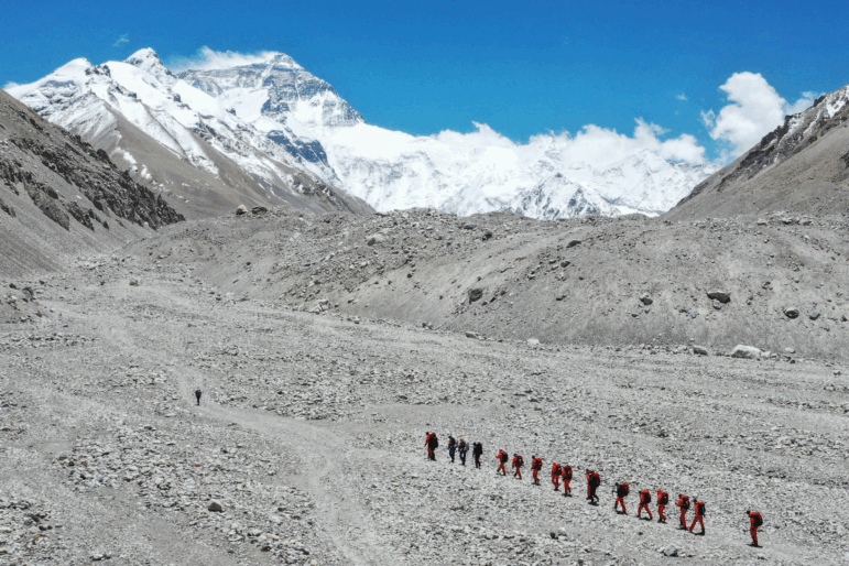 FILE - In this May 16, 2020 aerial photo released by Xinhua News Agency, Chinese surveyors hike toward a higher spot from the base camp on Mount Qomolangma at an altitude of 5,200 meters.
