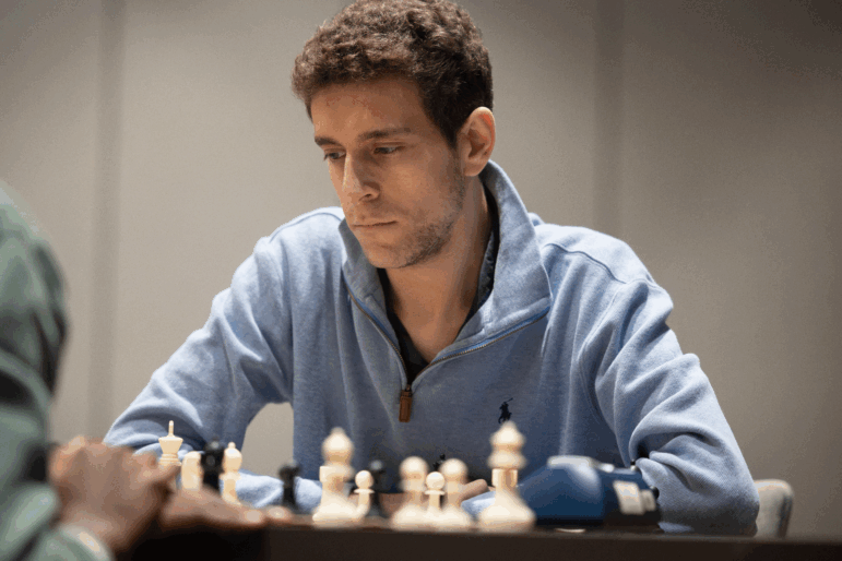 This undated photo released by the Charlotte Chess Center shows Daniel Naroditsky playing chess on the board.