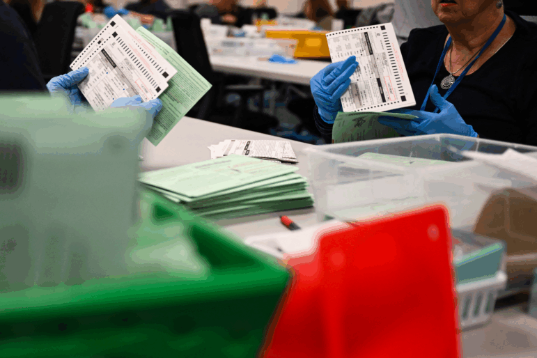 Election workers open and inspect mail-in ballot envelopes for Arizona’s 2024 general election inside the Maricopa County Tabulation and Election Center in Phoenix.