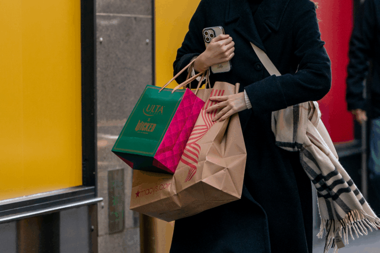 NEW YORK, NEW YORK - NOVEMBER 29: A person walks down a street with shopping bags on November 29, 2024 in New York City. Black Friday sales will give economists a glimpse into consumers' holiday shopping mood. (Photo by David Dee Delgado/Getty Images)