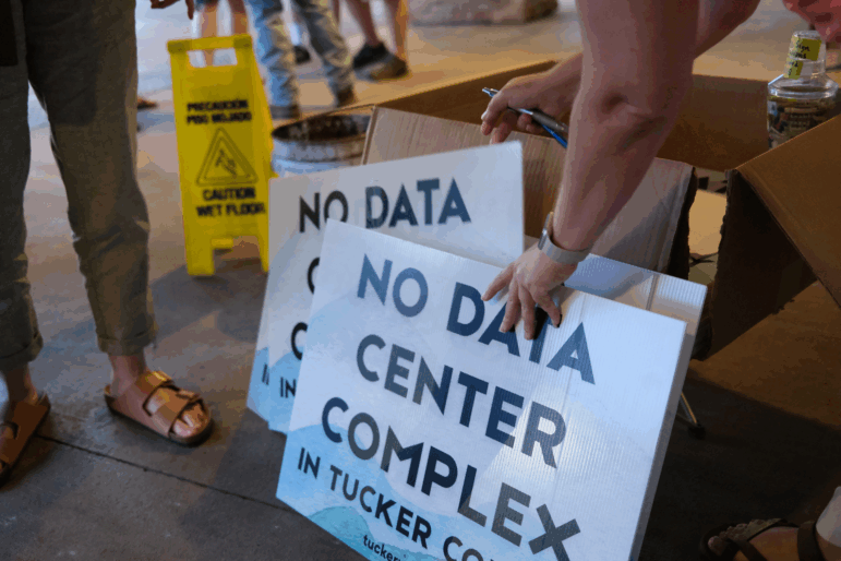 Volunteers hand out yard signs in June against a data center complex in West Virginia.
