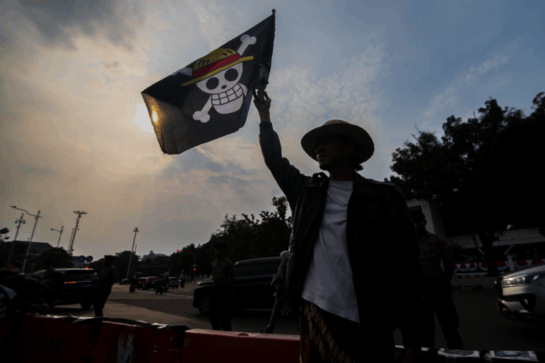 A number of human rights activists carry posters and wave the Straw Hat Pirates' Jolly Roger flag from the anime One Piece during the 873rd Kamisan Action  in Jakarta, Indonesia, on August 14, 2025.