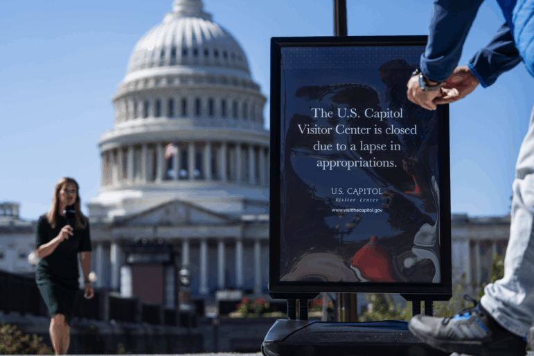 A news crew films a segment near a sign indicating that the Capitol Visitor Center is closed due to the government shutdown on Oct. 1.