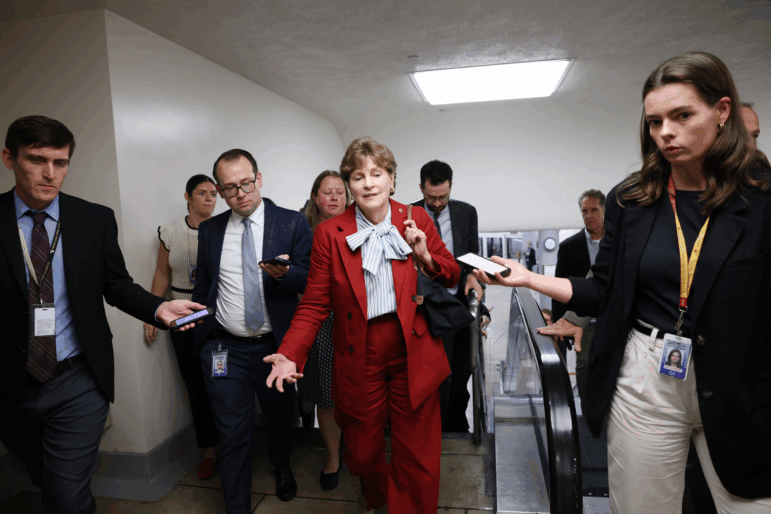 Sen. Jeanne Shaheen, D-N.H., speaks to reporters as she walks through the Senate subway in the U.S. Capitol on Sept. 30 in Washington.