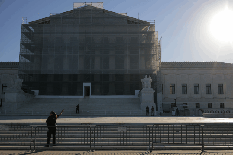 U.S. Supreme Court Police direct visitors from behind security barriers in front of court building, which is obscured in construction scaffolding, on the first day of the Court’s new term on Oct. 6 in Washington, D.C.
