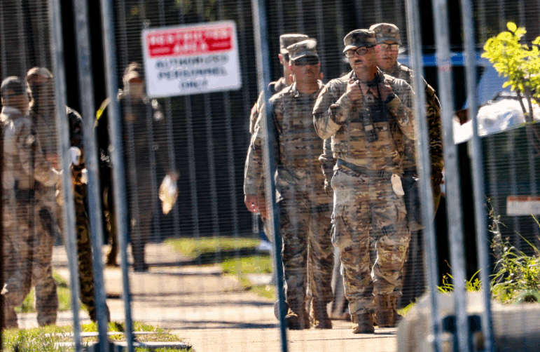National Guard members walk around outside of the U.S. Immigration and Customs Enforcement holding facility in Broadview, Illinois on Oct. 9.