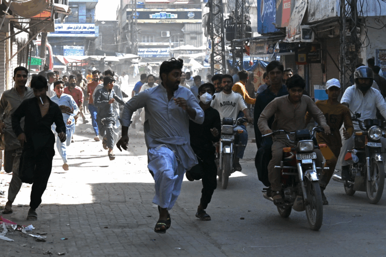 Tehreek-e-Labbaik Pakistan party activists run from police during a protest in support of Palestinians, in Muridke, Pakistan, on Oct. 13.