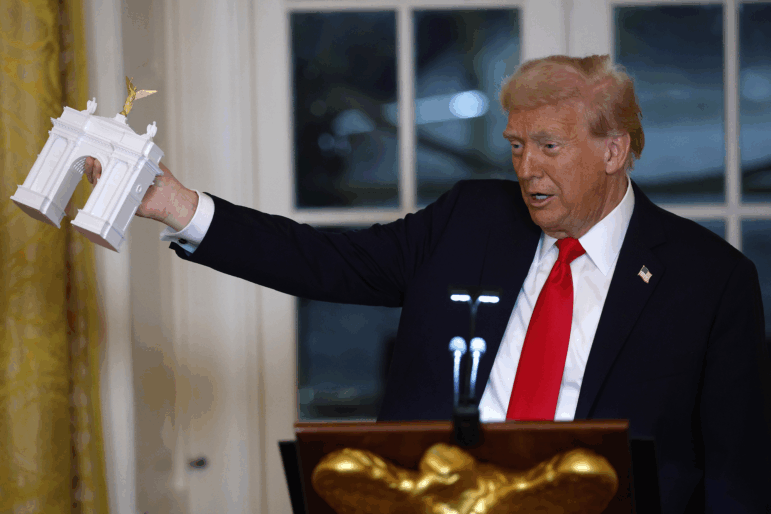 President Donald Trump shows off a model of a proposed new arch for Washington, D.C. during remarks at a fundraising dinner in the East Room of the White House on Wednesday.
